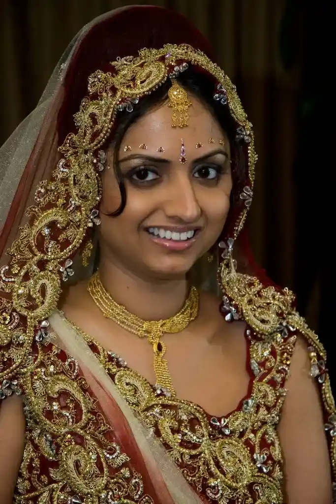 Bride wearing ornate red and gold bridal attire at destination wedding